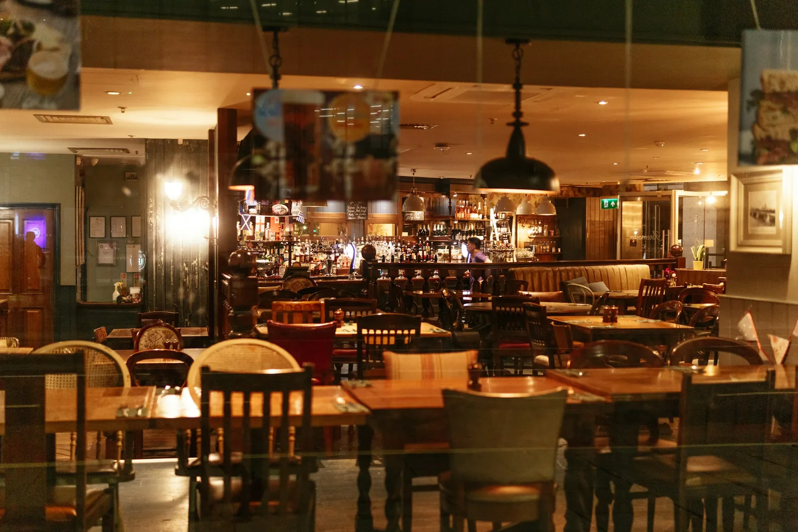The interior of a traditional pub with timber tables and a bar.